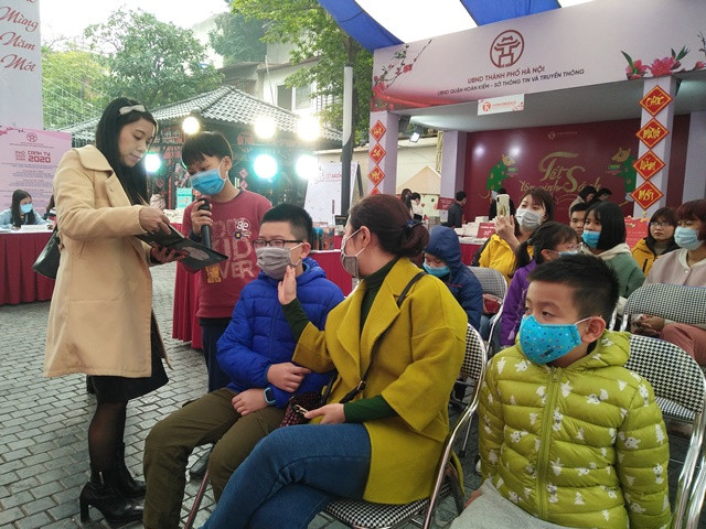 Không ai cảm thấy khó chịu với chiếc khẩu trang khi đọc sách tương tác tại Phố sách Xuân Canh Tý 2020. Ảnh: Bình Thanh