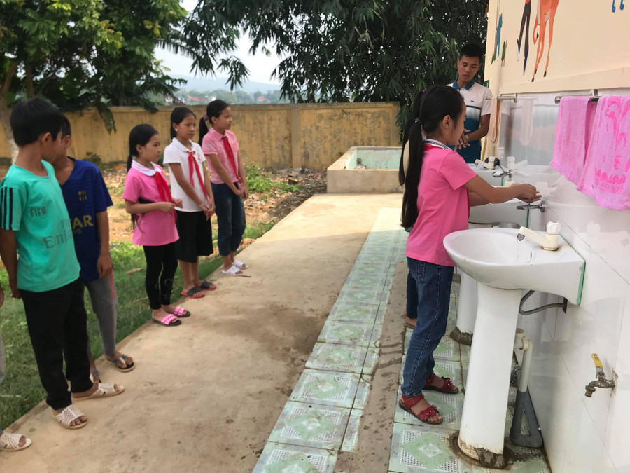 Học sinh rửa tay đúng cách với xà phòng sau khi đi vệ sinh.