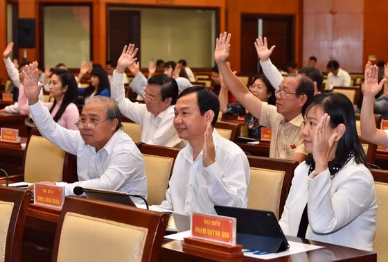 Các đại biểu thông qua Nghị quyết kỳ họp. - Ảnh: SGGP
