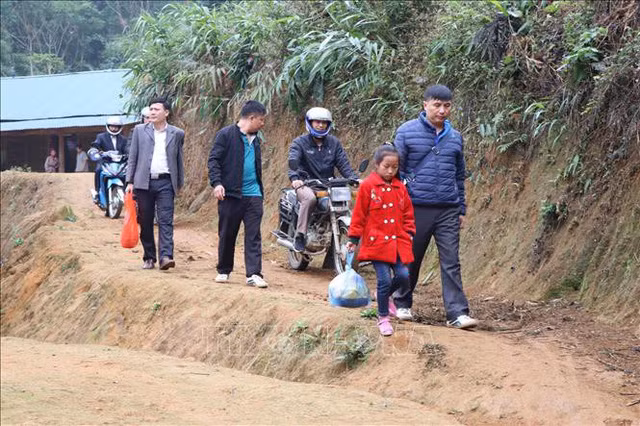 Thầy giáo Trường Phổ thông Dân tộc Bán trú Tiểu học Lang Thíp (Yên Bái) đưa các em ra lớp học. - Ảnh: TTXVN.