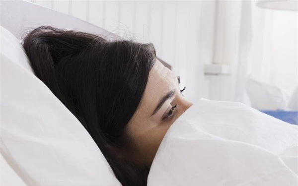 Em mệt mỏi trên giường bệnh vì động thai. (Ảnh minh họa).