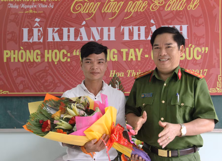 Đại tá Trần Minh Thuỳ, phó GĐ công an tỉnh Quảng Bình tặng hoa chúc mừng Sỹ với lớp học “đặc biệt” từ diễn đàn “Lắng nghe và chia sẻ” của CA huyện Lệ Thuỷ tỉnh Quảng Bình.