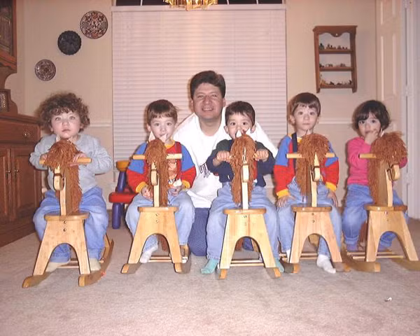 Năm đứa trẻ có trang phục và đồ chơi giống nhau. Ảnh:SWNS.com. Anh Jorge bên các con khi còn nhỏ. Ảnh: SWNS.com.
