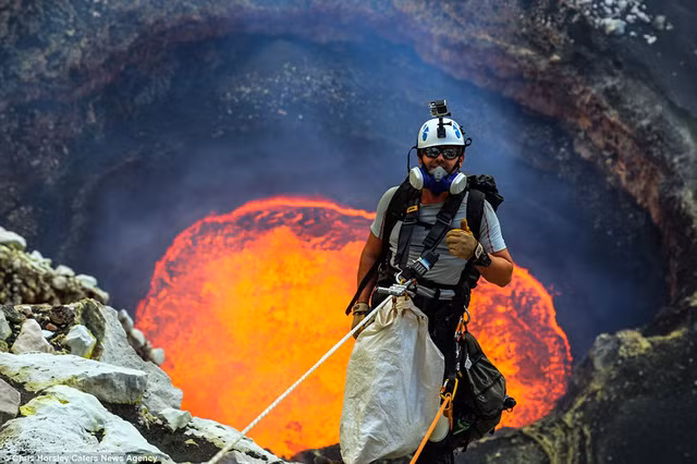 Vận động viên Nik Halik chụp hình trong khi đang leo xuống Marum – một miệng núi lửa đầy nham thạch nóng chảy ở Ambrym. Trước khoảnh khắc hiểm nguy, anh vẫn cười đầy mạnh mẽ và ghi dấu tay biểu tượng chiến thắng.