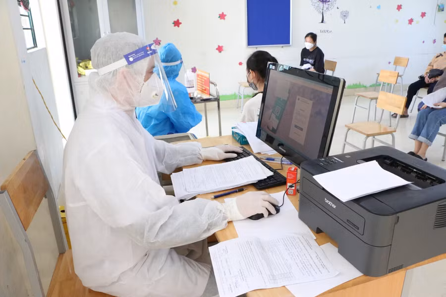 Tại phòng tiêm có nhân viên làm công tác nhập dữ liệu tiêm cho học sinh.