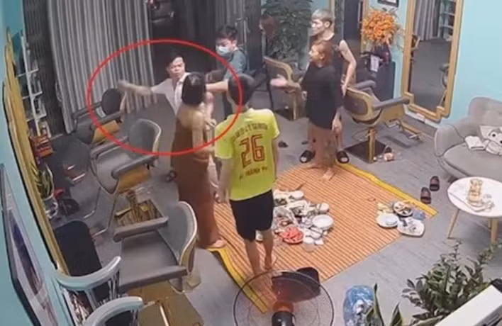 Phó trưởng Công an phường Sông Bằng (mặc áo sơ mi trắng) tát mạnh vào mặt cô gái trong quán tóc được camera an ninh ghi lại. 