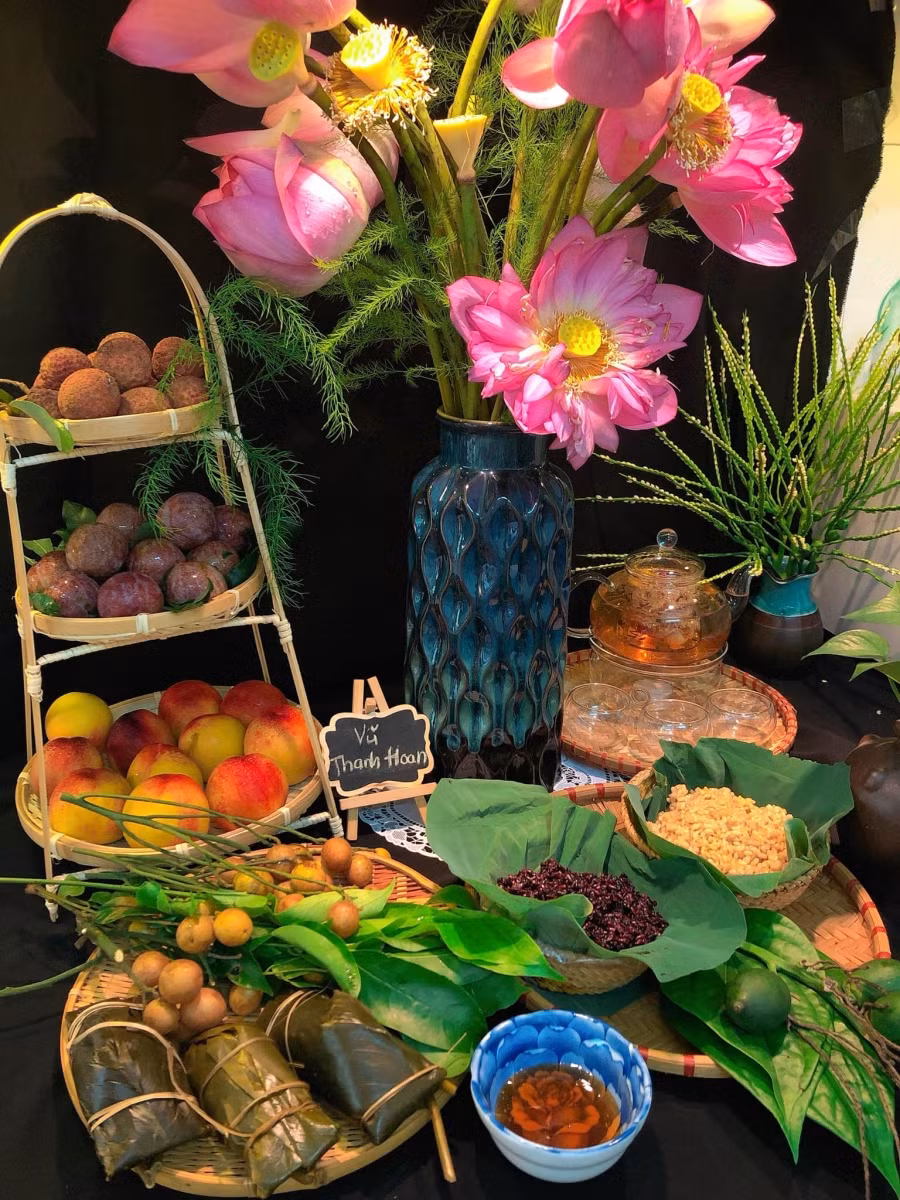 Mâm cúng của chị Vũ Thanh Hoan gồm có đầy đủ hoa quả đặc trưng của Tết Đoan Ngọ: Mận, đào, hồng bì, vải, bánh gio chấm mật mía, trầu cau; Hoa sen bách Diệp, hoa cau quế thơm nức; Trà hoa cúc, táo đỏ, kỳ tử. Và không thể thiếu: cơm rượu nếp cẩm, cơm rượu nếp thường.