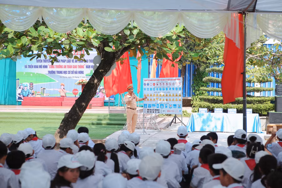 Các em học sinh nghe tuyên truyền về an toàn giao thông từ lực lượng Công an.