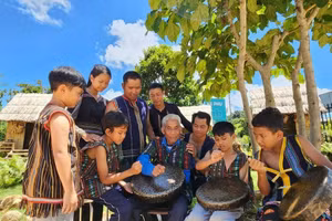 Các nghệ nhân người K'Ho truyền dạy đánh chiêng cho học sinh tại khu du lịch cộng đồng Làng K’Ho Cil. Ảnh: KHC.