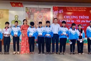 Bà Trần Thị Hồng, Phó Hiệu trưởng Trường THCS Nguyễn Du trao quà tết cho học sinh.