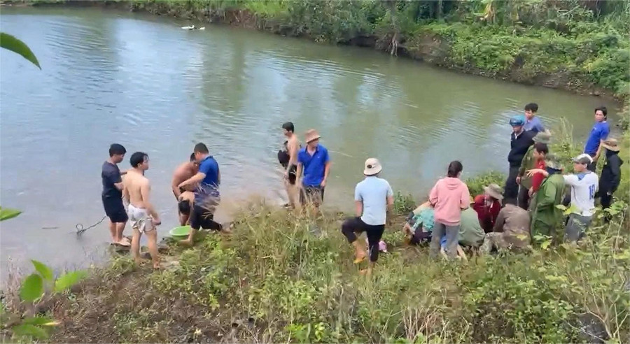 Người dân và cơ quan chức năng trục vớt 3 em nhỏ bị đuối nước.