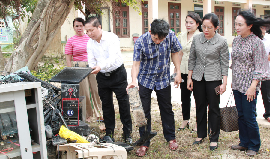Thứ trưởng Lê Tấn Dũng kiểm tra hệ thống máy tính của Trường Tiểu học An Định bị hư hỏng hoàn toàn sau lũ. (Ảnh: Thành Tâm)