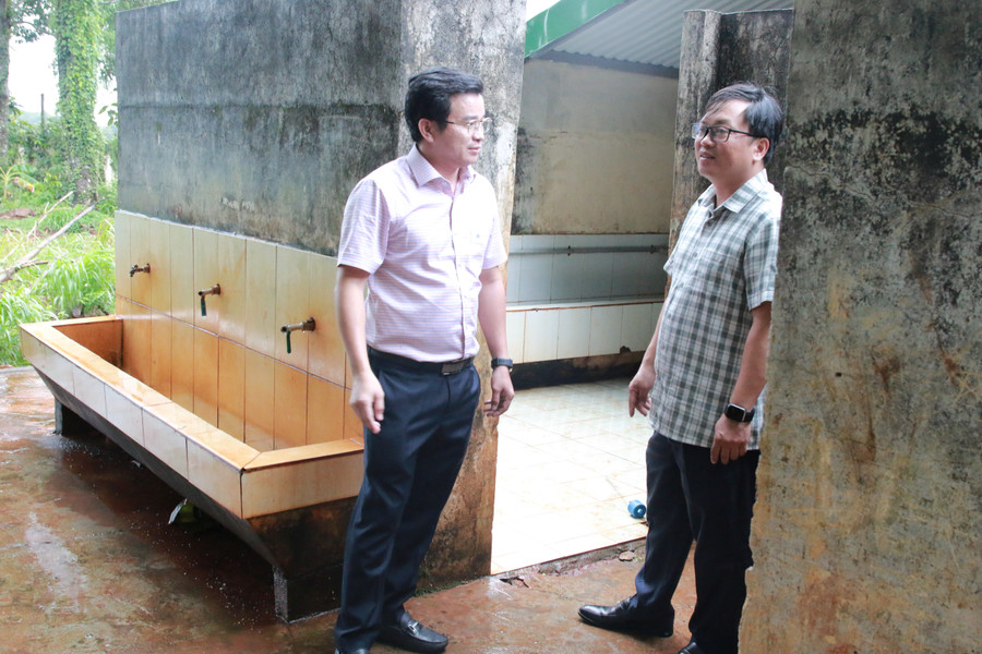 Ông Nguyễn Huy Dũng (bên phải) và bác sĩ Mai Văn Đỏ thống nhất phương án hỗ trợ 100 triệu để sửa chữa, nâng cấp 2 nhà vệ sinh. (Ảnh: TT) 1-chon.jpg