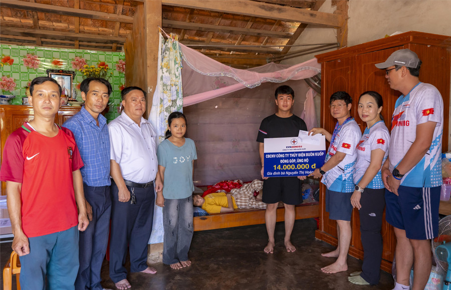Lãnh đạo Công ty Thủy điện Buôn Kuốp trao hỗ trợ cho em Ngọc Xuân Bình. (Ảnh: TT)