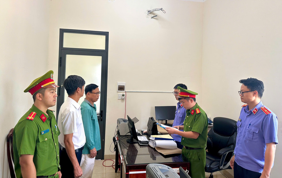 Cơ quan chức năng tống đạt các quyết định tố tụng đối với 2 bị can. (Ảnh: DQ)