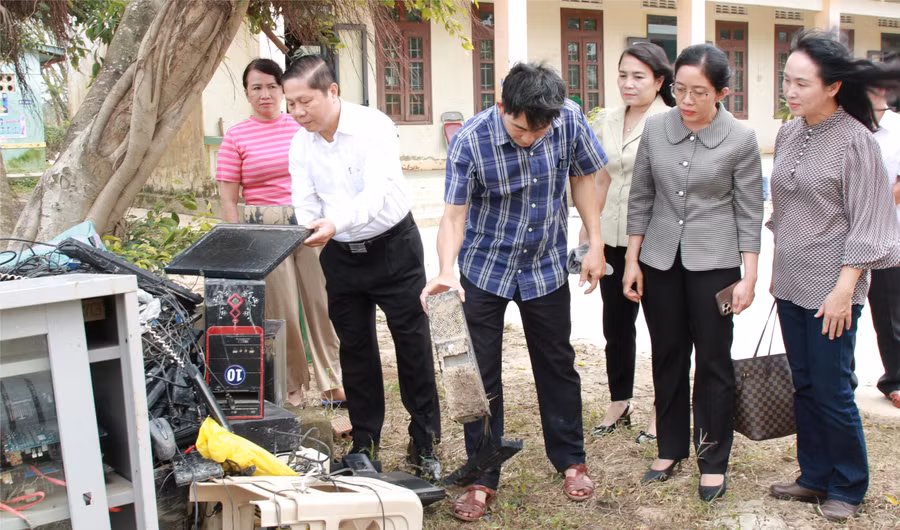 Thứ trưởng Lê Tấn Dũng kiểm tra hệ thống máy tính của Trường Tiểu học An Định bị hư hỏng hoàn toàn sau lũ. (Ảnh: Thành Tâm)