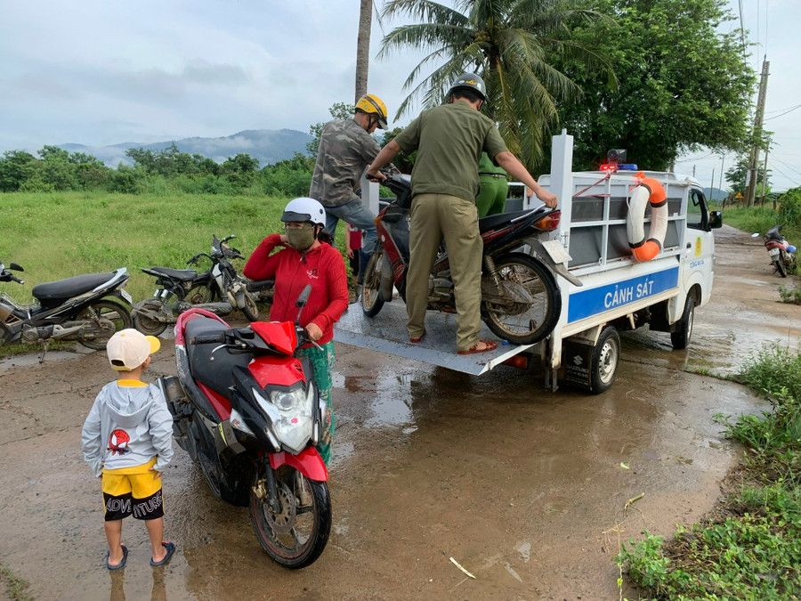 Nhờ sự giúp đỡ của lực lượng Công an, hàng trăm học sinh, người dân đã qua lại điểm ngập lụt an toàn. (Ảnh: QT) 1-hs.jpg