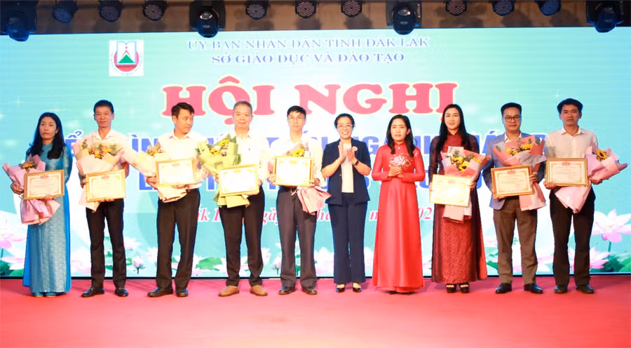 Phó Bí thư Tỉnh ủy Huỳnh Thị Chiến Hòa cùng Giám đốc Sở GD&ĐT Lê Thị Thanh Xuân khen thưởng cho các tập thể điển hình tiên tiến. (Ảnh: Thành Tâm)