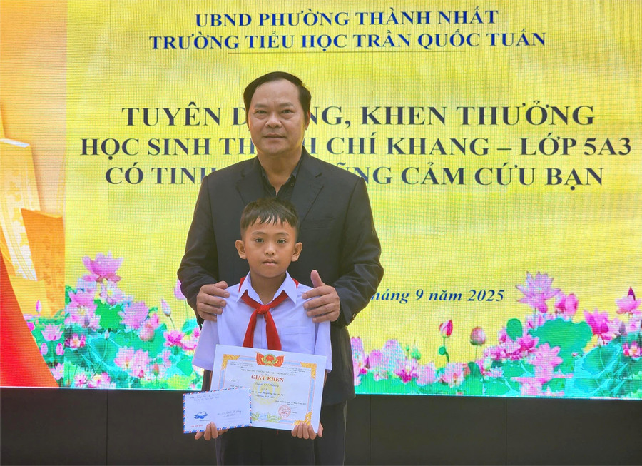 Ông Trần Xuân Kỳ - Hiệu trưởng nhà trường khen thưởng cho em Thạch Chí Khang. (Ảnh: TT) truong.jpg