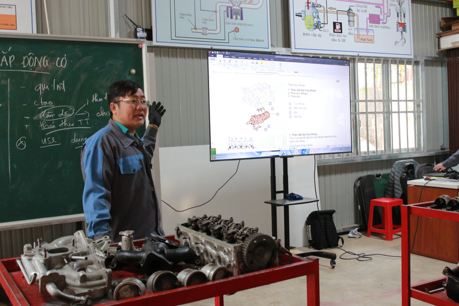 Giáo viên hướng dẫn thực hành lắp động cơ đốt trong cho học sinh tại Trường Trung cấp Tây Nguyên. (Ảnh: Thành Tâm) 1-3.jpg