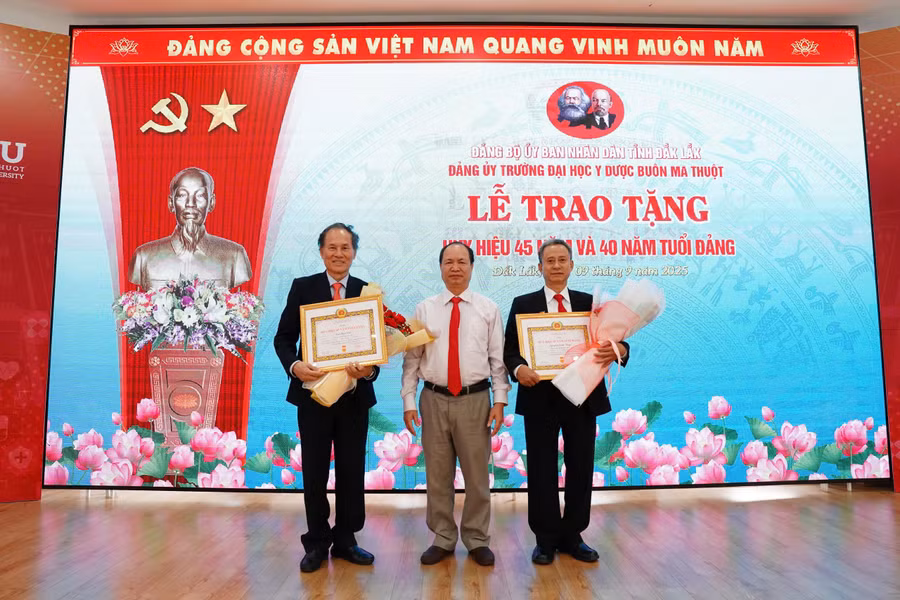 GS.TS Cao Tiến Đức (bên trái) và TS Nguyễn Sanh Tùng (bên phải) nhận Huy hiệu 45 và 40 năm tuổi Đảng.