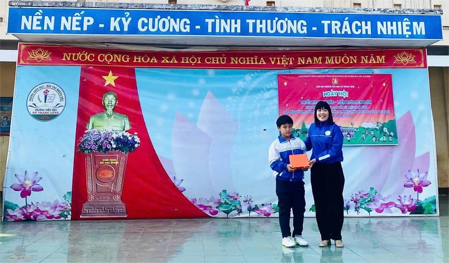 Cô Lê Thị Việt, Hiệu trưởng nhà trường biểu dương, khen thưởng học sinh Hoàng Bảo Lâm. (Ảnh: NT)