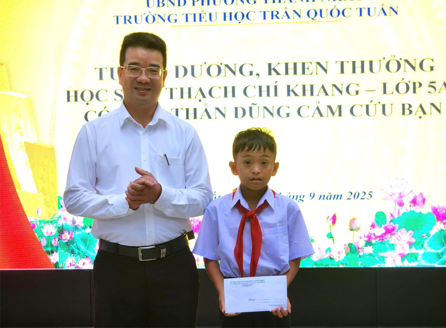 Ông Nguyễn Đình Tâm - Chủ tịch UBND phường Thành Nhất trao thưởng cho em Thạch Chí Khang. (Ảnh: TT) tam.jpg