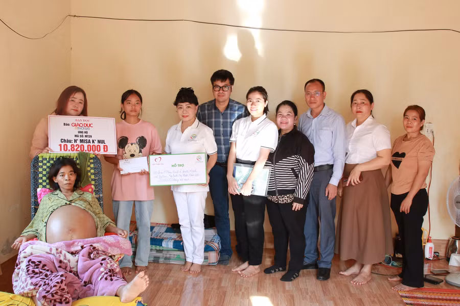 Trao tiền của bạn đọc và các nhà hảo tâm cho mẹ con H' Misa K'nul. (Ảnh: TT)