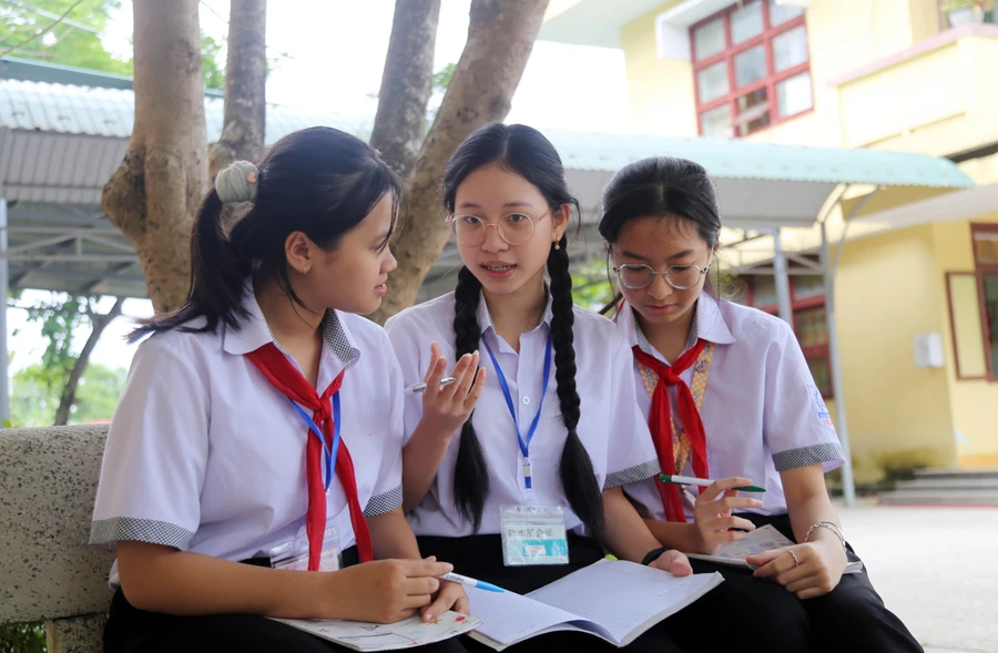 Em Nguyễn Ngọc Thủy Tiên (ở giữa) đang giảng bài tập cho 2 học sinh khóa dưới.