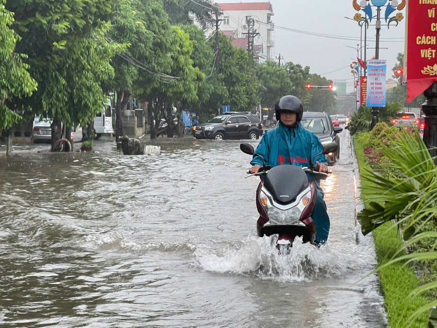 Chị Đặng Thị Cẩm Trúc cho biết, một số tuyến đường ngập sâu nên chị phải đi vòng sang tuyến đường khác để đưa con tới trường. 15.jpg