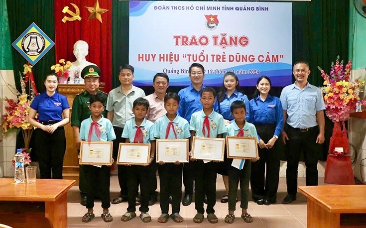 Đại diện lãnh đạo Tỉnh đoàn Quảng Bình trao tặng Huy hiệu "Tuổi trẻ dũng cảm" cho 5 học sinh.