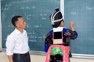 Thầy giáo Lỳ Bá Của (giáo viên Trường Phổ thông DTBT Tiểu học Hữu Khuông, Nghệ An) dạy học xóa mù chữ cho người dân. Ảnh: Hồ Lài