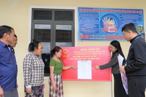 Cán bộ xã Nậm Cắn (Nghệ An) hướng dẫn người dân bản Trường Sơn đọc thông tin danh sách cử tri ở điểm bầu cử. Ảnh: Hồ Lài