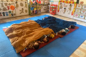 Các em học sinh ngủ trưa với nệm và đắp chăn ấm.