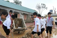 Học sinh Trường THCS Kỳ Tân, xã Tân Kỳ, Nghệ An tham gia dọn dẹp, vệ sinh sân trường sau lũ. Ảnh: Hồ Lài