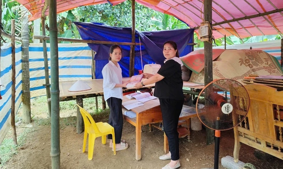 Cô giáo Hoàng Thị Như Oanh, Hiệu trưởng Trường TH&THCS Phúc Ninh cùng nhà trường thăm hỏi, động viên em Nông Thị Huyền Trang tại góc học tập bên lán tạm.