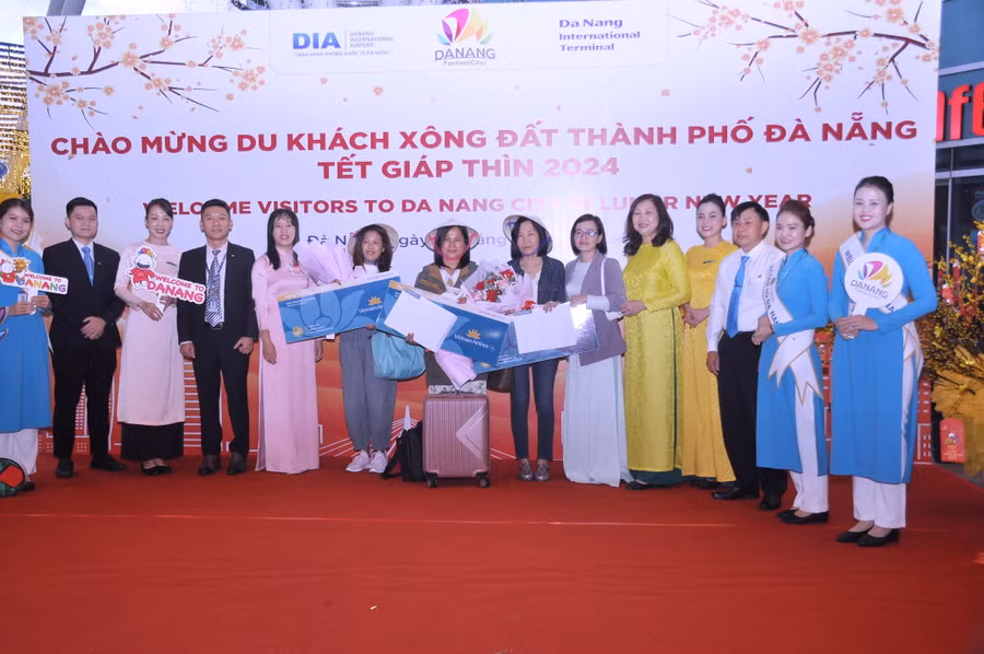 Lãnh đạo Sở Du lịch Đà Nẵng cùng các đơn vị liên quan tặng quà cho các du khách đầu tiên đến Đà Nẵng trong năm mới Giáp Thìn.