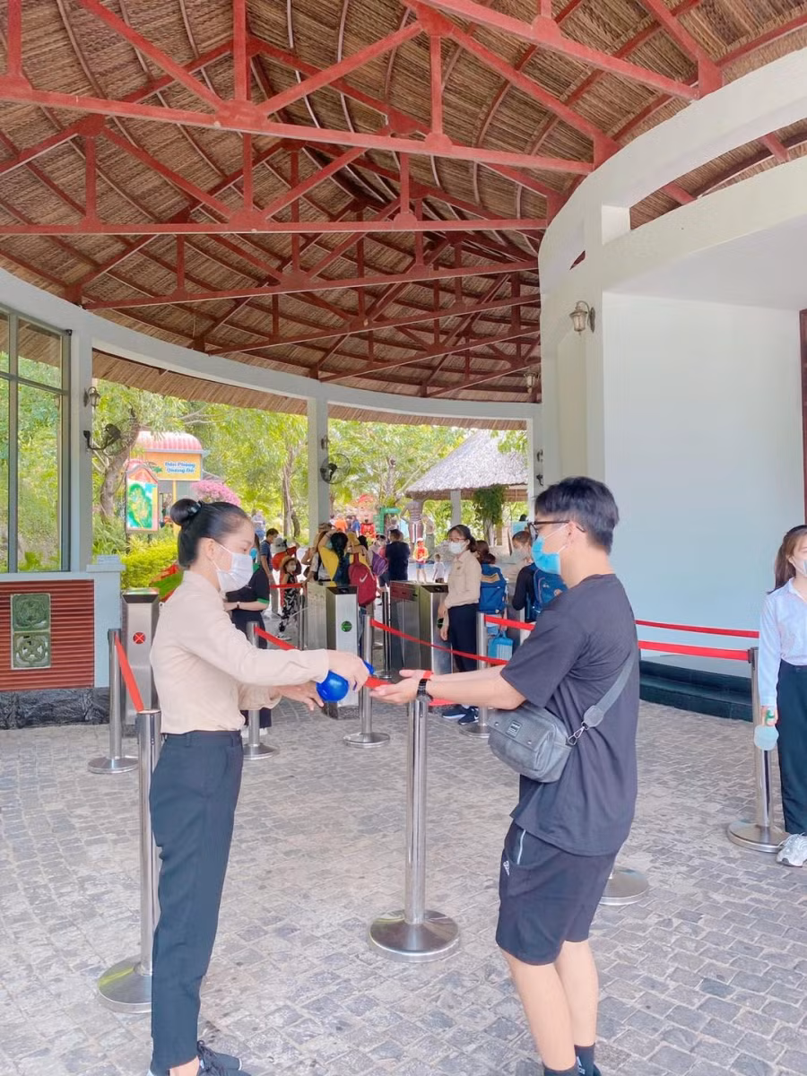 Khách du lịch sát khuẩn tay trước khi vào khu du lịch.
