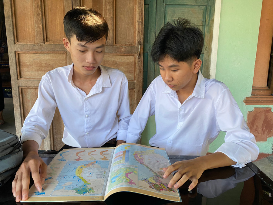 Em Huỳnh Quốc Huy (bên phải) và em Trương Huỳnh Công Duy (bên trái) đang tranh thủ xem Atlat trước khi bước vào phòng thi. Ảnh: Hoàng Vinh.