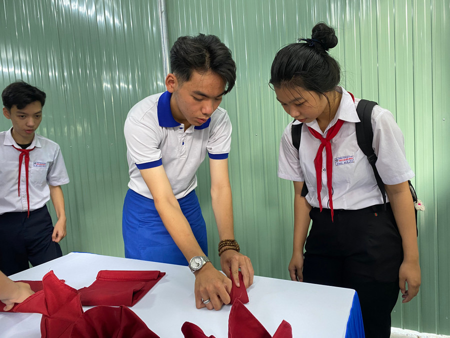 Học sinh được hướng dẫn gấp khăn ăn.