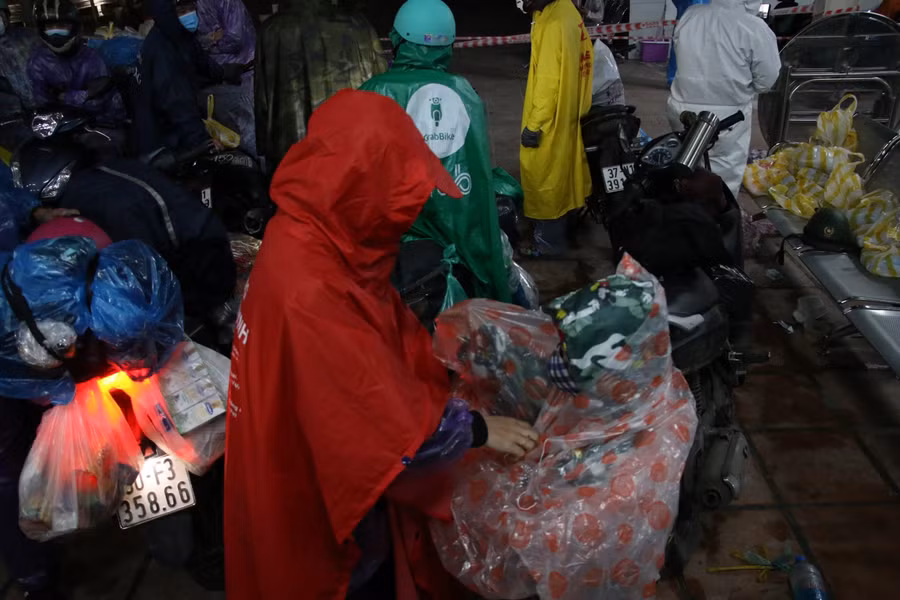 Các em nhỏ được ba mẹ mặc áo mưa trước khi lên đường tiếp tục hành trình về quê.