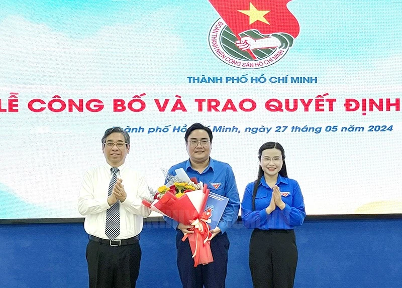 Bà Nguyễn Phạm Duy Trang trao quyết định và ông Nguyễn Phước Lộc tặng hoa chúc mừng anh Ngô Minh Hải, Bí thư Thành Đoàn TPHCM.