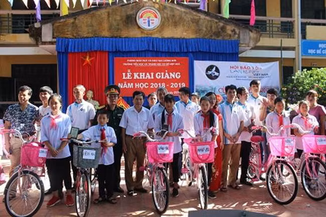 Ban tổ chức và khách mời chụp hình lưu niệm với các em HS được tặng xe đạp tại buổi lễ .