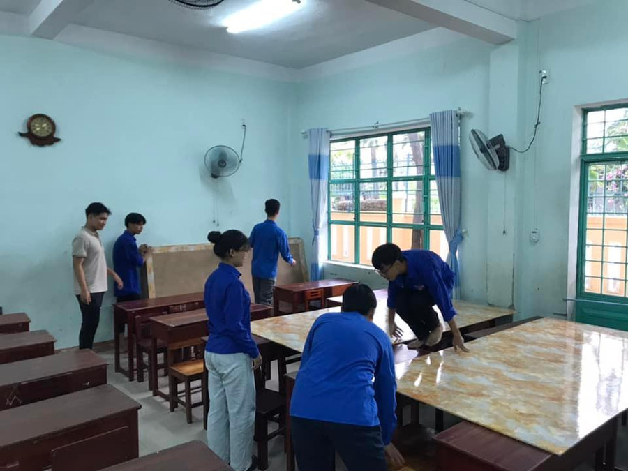 Trường học được trưng dụng làm nơi tránh bão cho người dân. Trong ảnh là Đoàn viên Thanh niên sắp xếp bàn học để người dân đến trú bão.