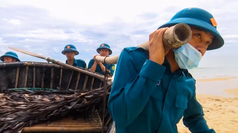 Dân quân tự vệ giúp dân đưa thuyền thúng lên bờ tránh bão Noru. 