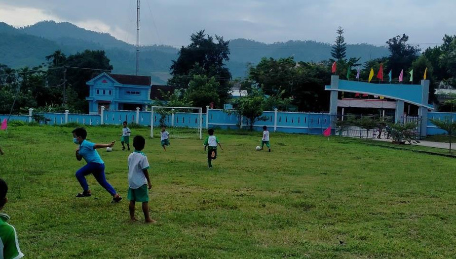 Các em học sinh vui vẻ đá bóng trong lúc giải lao.