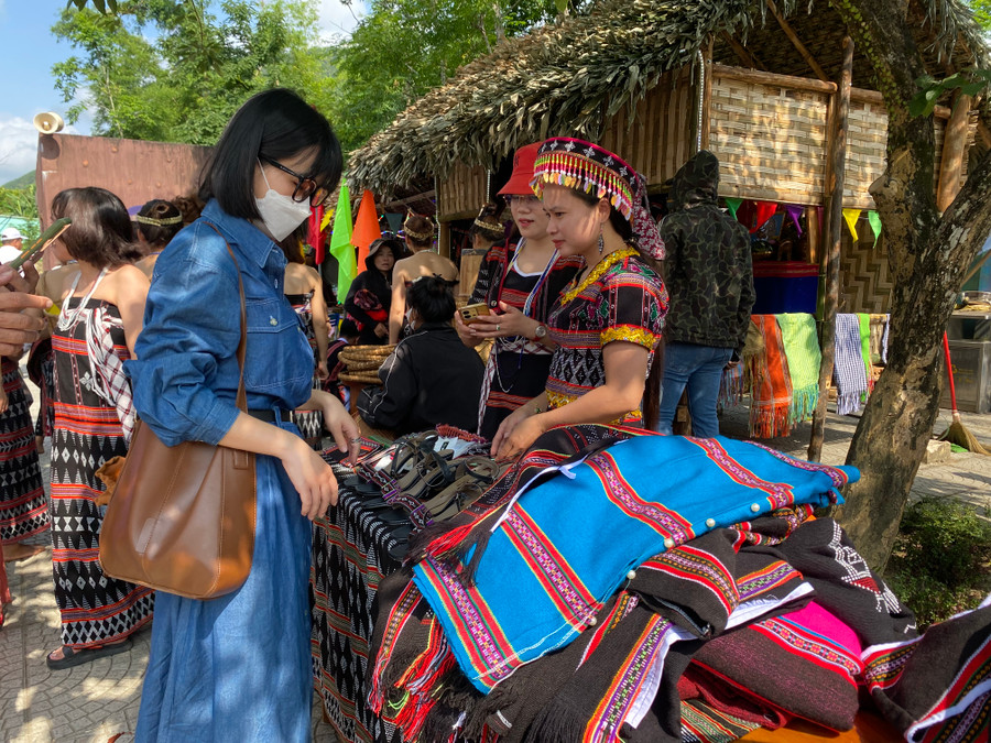 Chị Châu Diệu Bình - trú Sơn Trà, TP. Đà Nẵng đang lựa những trang phục thổ cẩm để mua về tặng người thân. Ảnh: Hoàng Vinh.