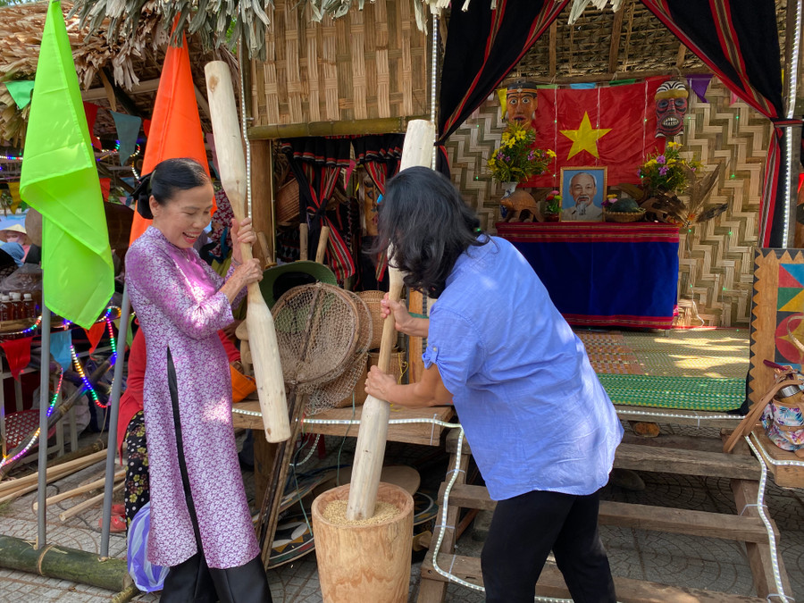 Du khách trải nghiệm giã gạo. Ảnh: Hoàng Vinh.