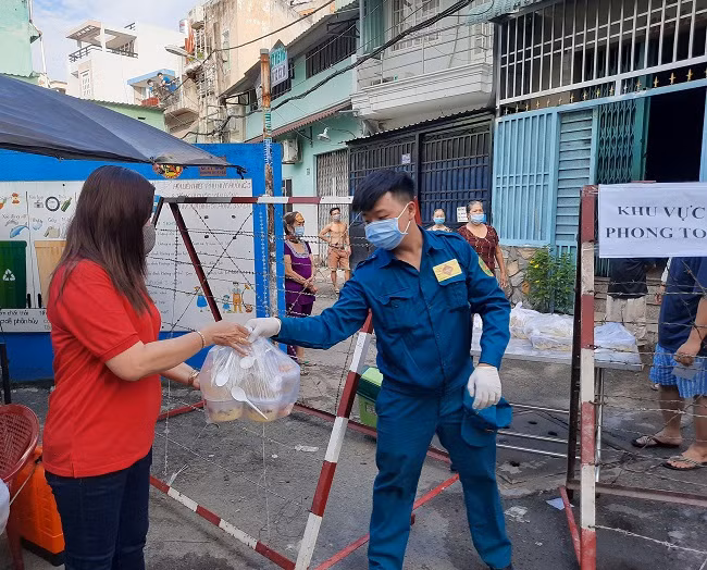 Lực lượng chức năng hỗ trợ chuyển thức ăn vào cho các hộ dân.