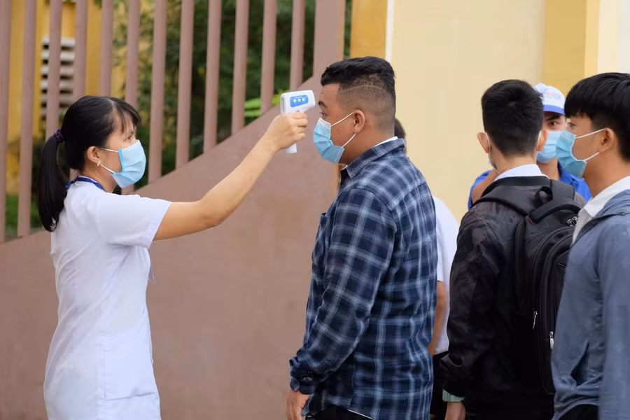 Đo thân nhiệt cho thí sinh trước khi bước vào điểm thi.
